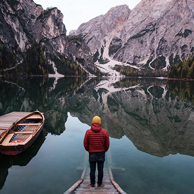 Rear view of man standing by a lake in the Dolomites